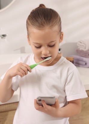 Young person learning to brush teeth via a virtual check up.