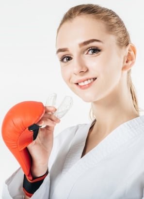 Young person holding mouthguard in hands for boxing. 